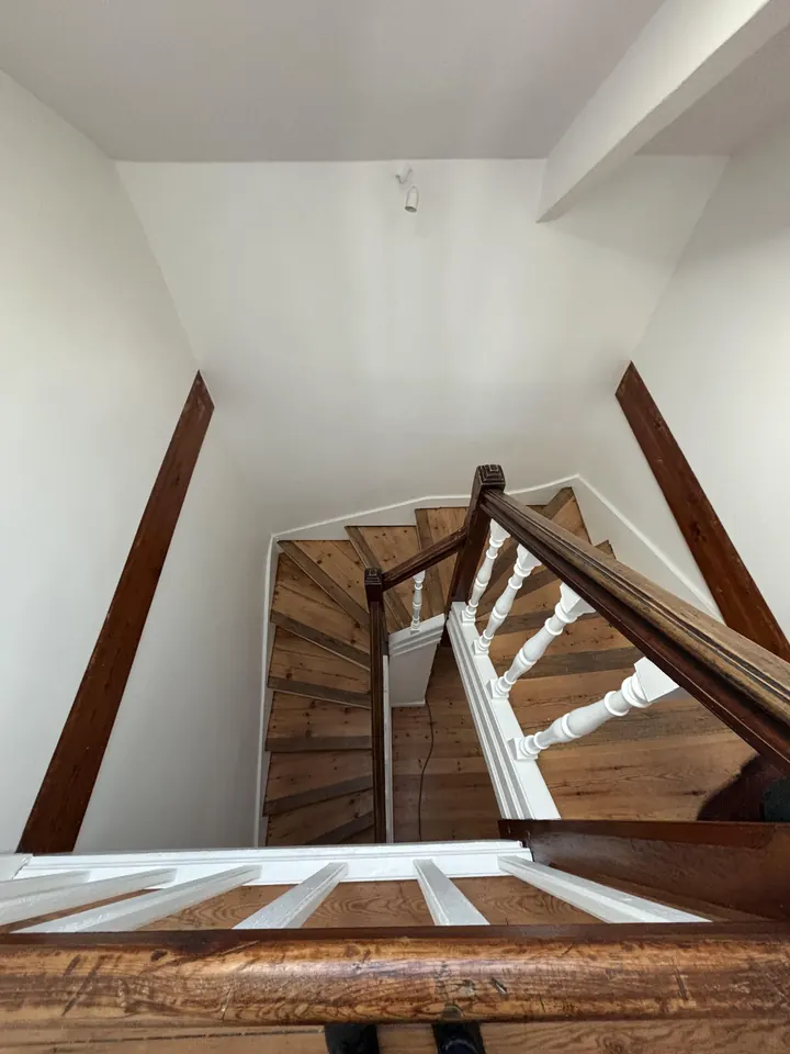 L'escalier rénové, marches en bois clair et balustres blancs