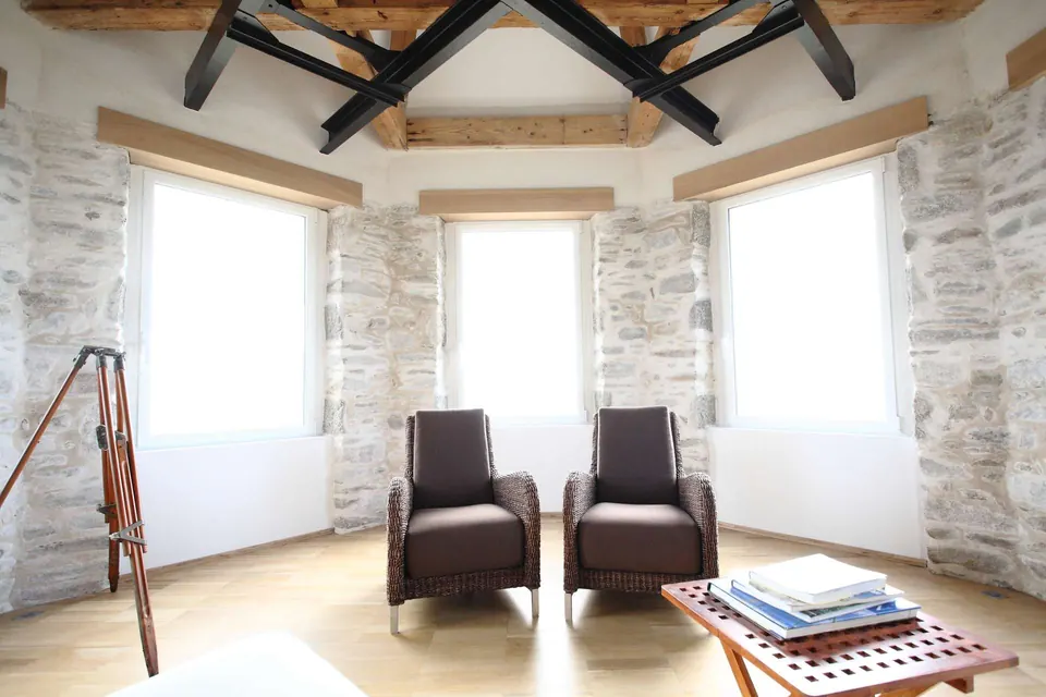 Maison d'architecte : murs de pierre blanchie et charpente apparente